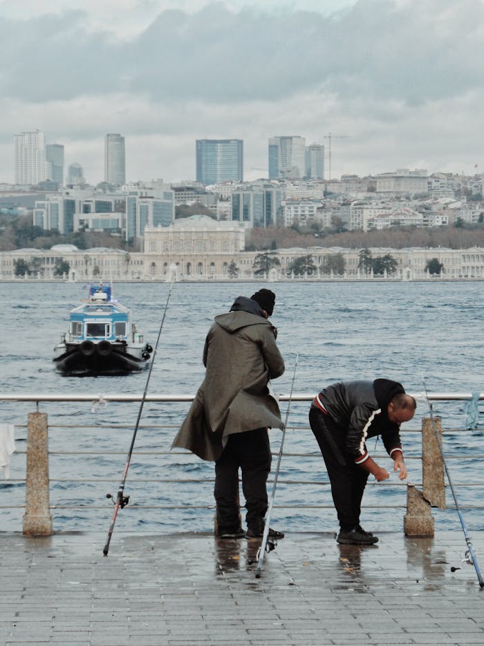 Fishermen casting lines on the Bosphorus with Istanbuls city skyline in the background.